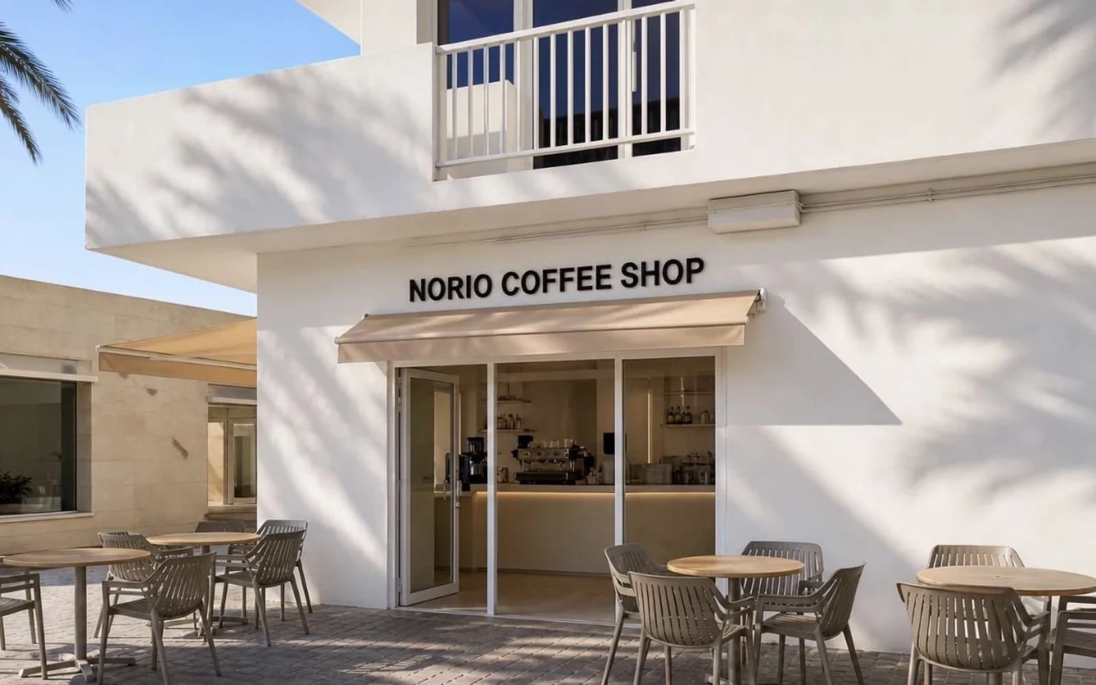 Sunlit white NORIO Coffee Shop storefront with outdoor tables